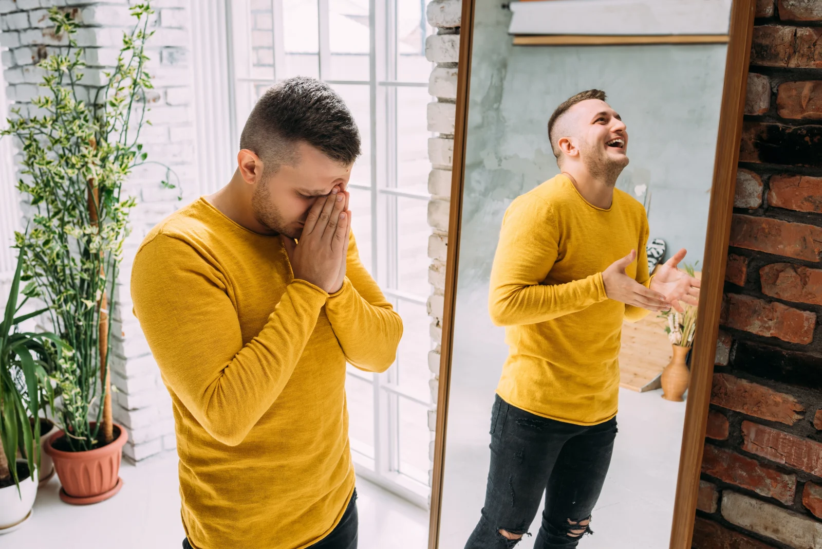 Man in two moods, upset and celebrating, in front of a mirror